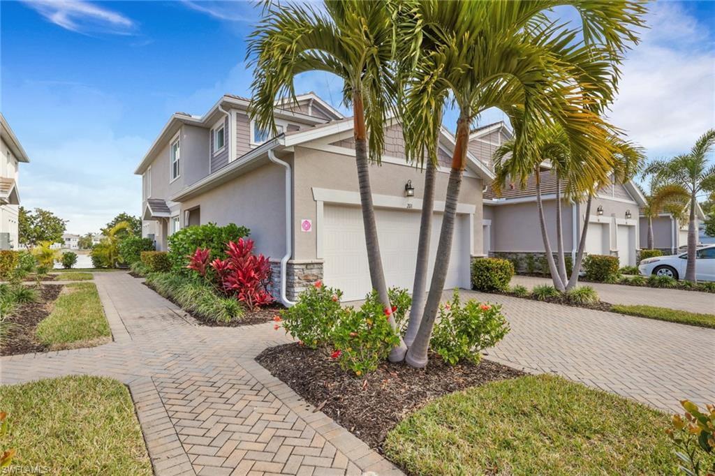 4687 Arboretum Circle, Unit 101 Naples, FL 34112 - Photo 1 of 30 a front view of a house with a yard and a garden