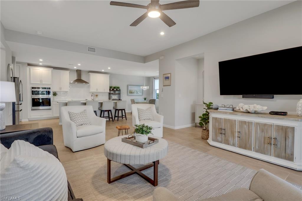 4687 Arboretum Circle, Unit 101 Naples, FL 34112 - Photo 11 of 30 a living room with furniture and a flat screen tv