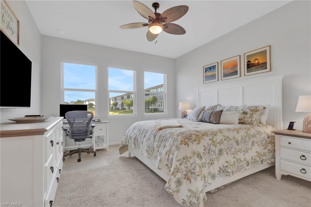 4687 Arboretum Circle, Unit 101 Naples, FL 34112 - Photo 15 of 30 a bedroom with a bed and a flat screen tv