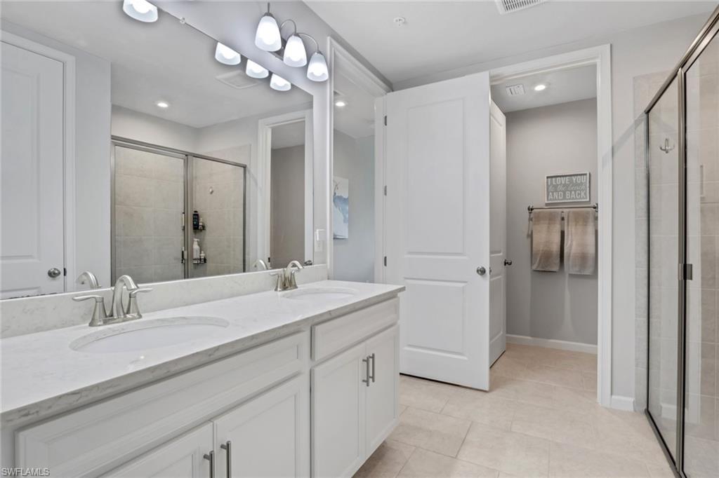 4687 Arboretum Circle, Unit 101 Naples, FL 34112 - Photo 18 of 30 a spacious bathroom with a double vanity sink mirror and shower