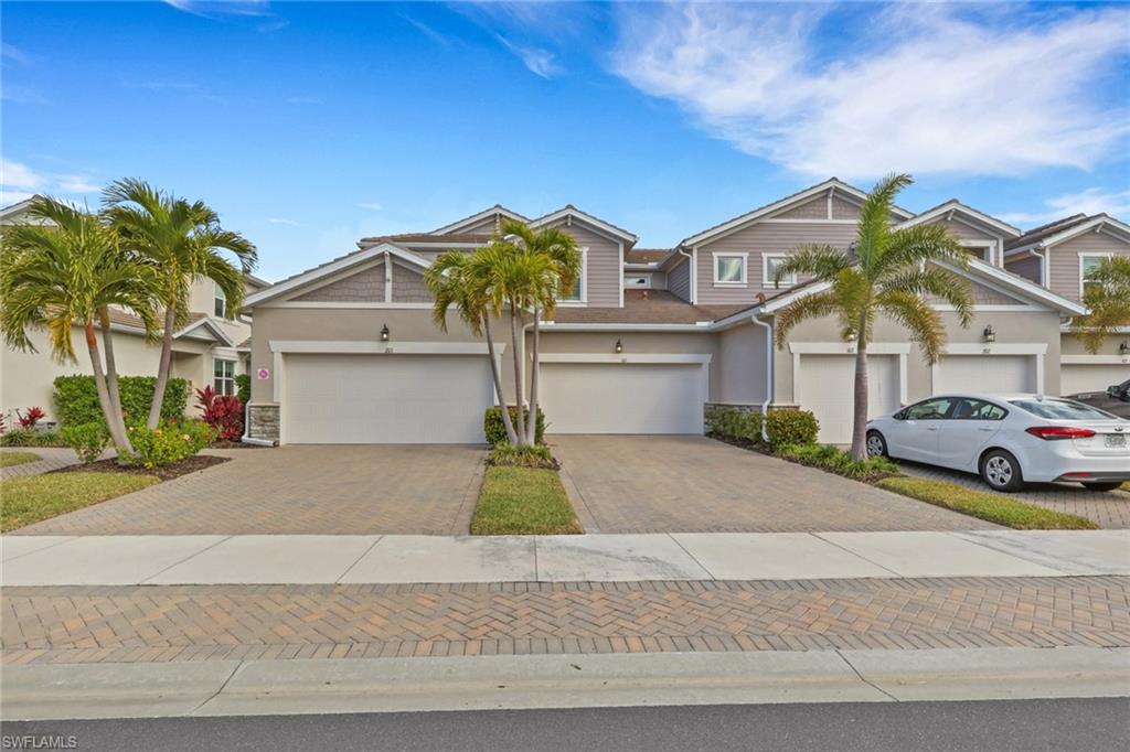 4687 Arboretum Circle, Unit 101 Naples, FL 34112 - Photo 3 of 30 a front view of a house with a yard and garage