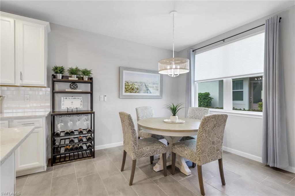 4687 Arboretum Circle, Unit 101 Naples, FL 34112 - Photo 5 of 30 a dining room with furniture a chandelier and window