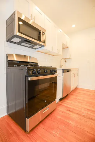 a kitchen with granite countertop a stove and a microwave