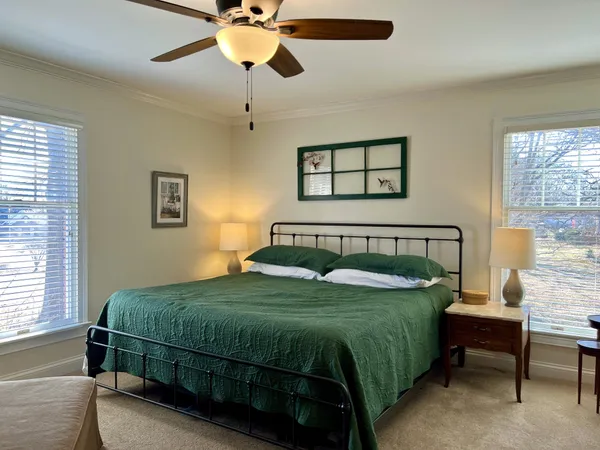 a bedroom with a bed a chandelier and a dresser