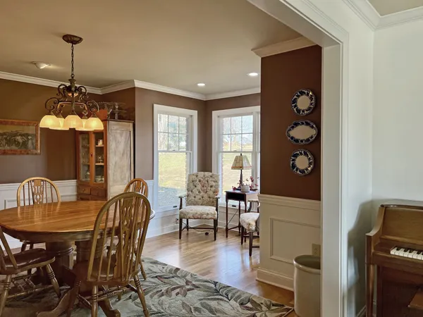 a dining room with furniture a chandelier and window