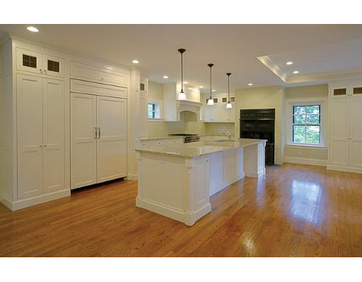 57 Upland Road Brookline, MA 02445 - Photo 4 of 7 a open kitchen with kitchen island a sink dishwasher a refrigerator and a fireplace with wooden floor