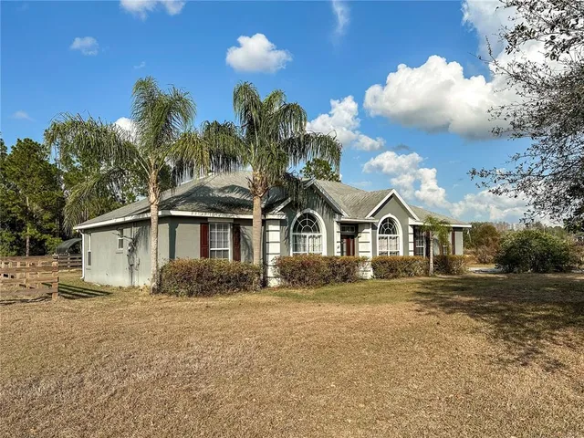 a front view of a house with a yard and trees