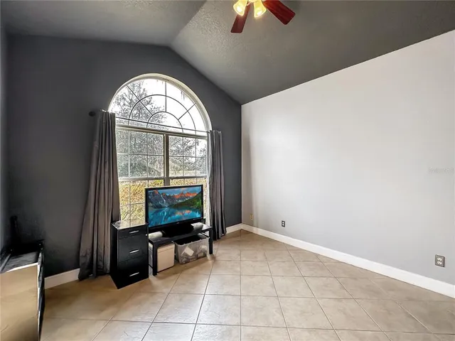 an empty room with windows and fireplace
