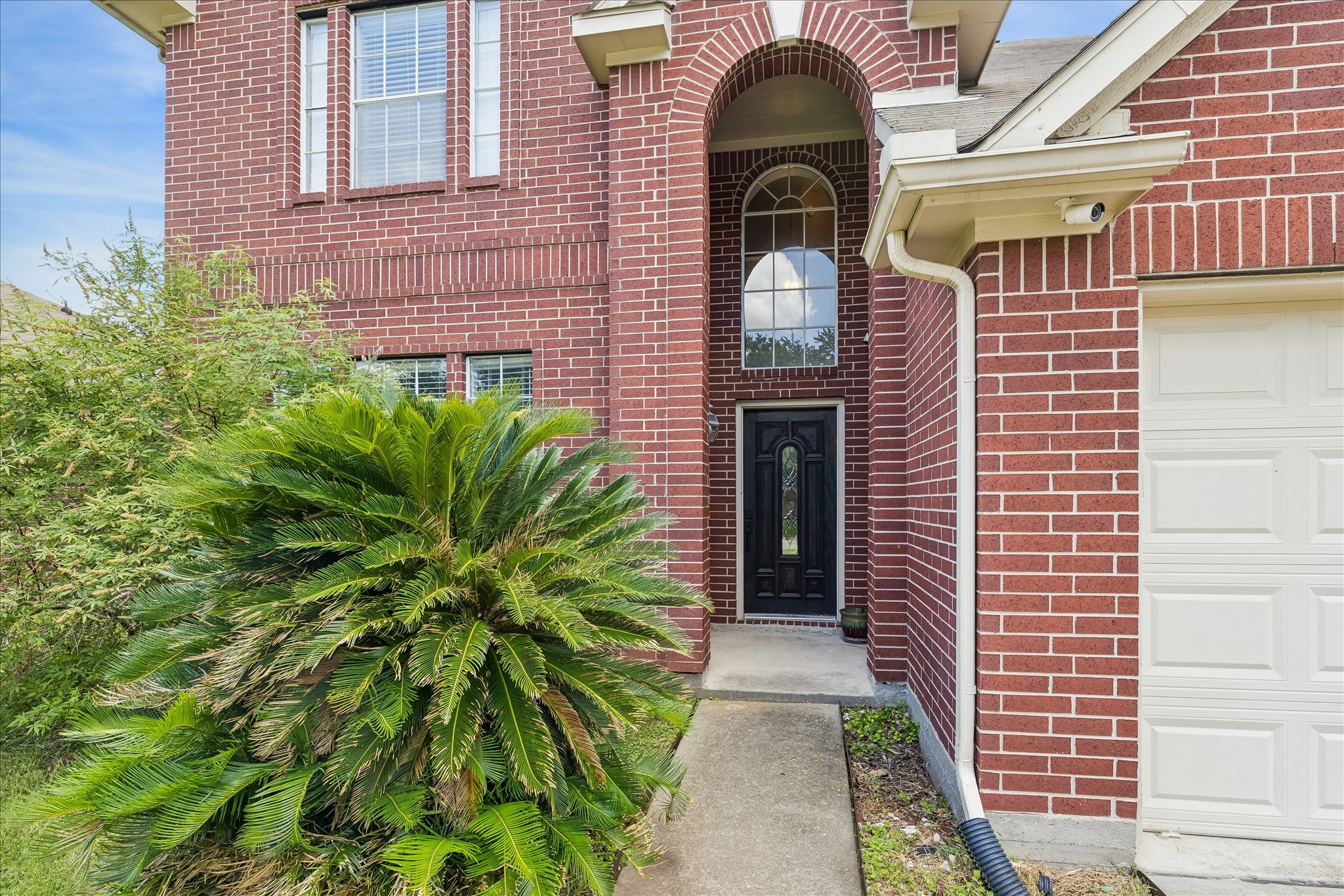 23234 Grand Rapids Lane Spring, TX 77373 - Photo 2 of 30 Dramatic arched entryway framed in brick with soaring two-story windows and a rich wood front door make a lasting first impression.