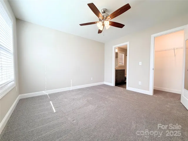 an empty room with a window and a ceiling fan