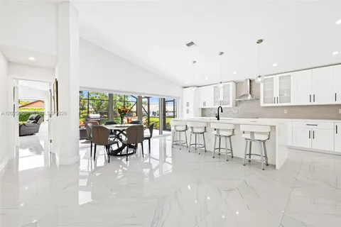 a large white kitchen with lots of counter space and furniture