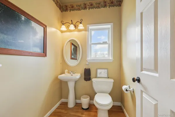 a bathroom with a toilet sink vanity mirror and tub