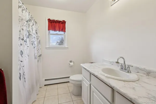 a bathroom with a granite countertop sink a toilet and a shower