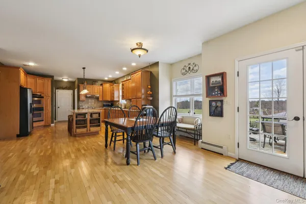 a living room with furniture and kitchen view with wooden floor