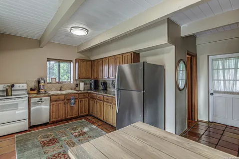 a kitchen with stainless steel appliances granite countertop a refrigerator a sink a stove and white cabinets