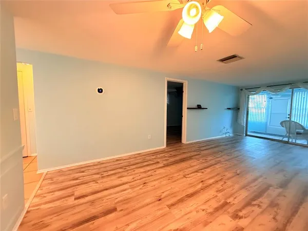 a view of empty room with wooden floor