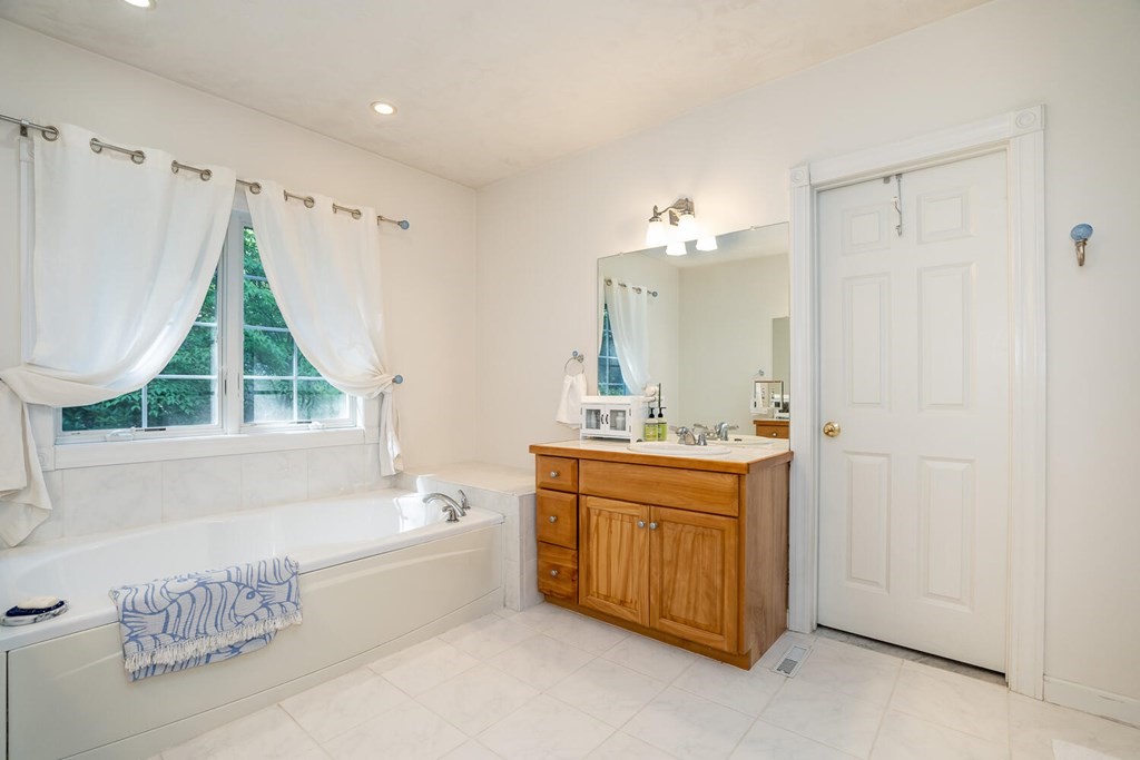 150 East Leverett Road Amherst, MA 01002 - Photo 31 of 42 a bathroom with a tub sink and mirror
