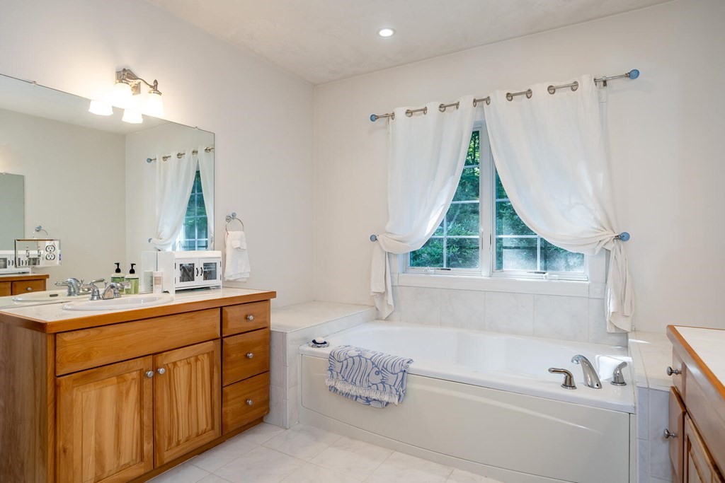 150 East Leverett Road Amherst, MA 01002 - Photo 32 of 42 a bathroom with a tub sink and mirror