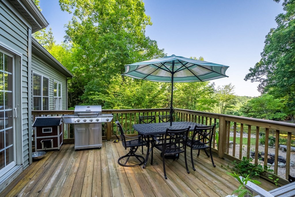 150 East Leverett Road Amherst, MA 01002 - Photo 8 of 42 a view of a roof deck with table and chairs under an umbrella with wooden floor