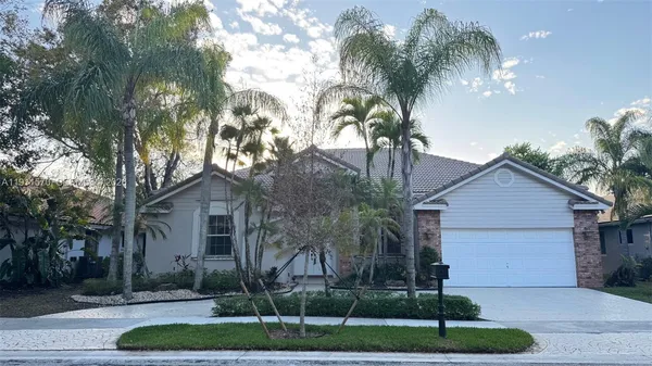 a front view of a house with a yard and potted plants