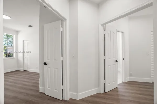 a view of a hallway with wooden floor