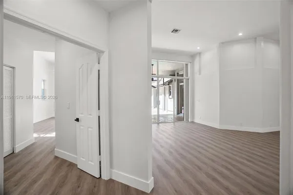 a view of a hallway with wooden floor