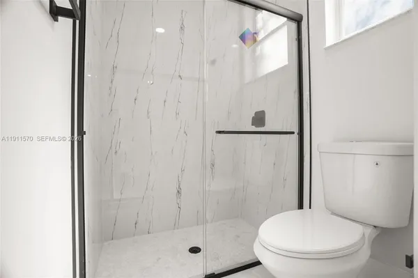 a bathroom with a toilet and a shower