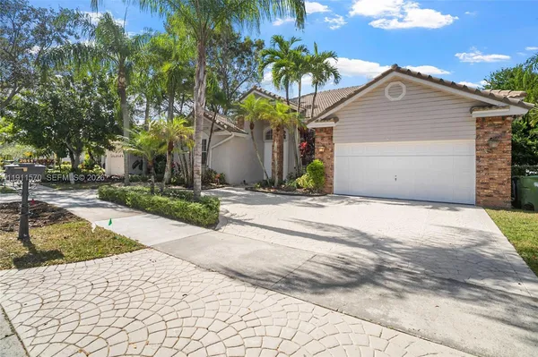 a front view of a house with a yard and potted plants