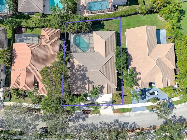 an aerial view of a house with a yard and trees