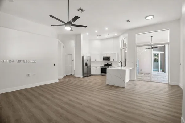 a view of kitchen and living room with a ceiling fan