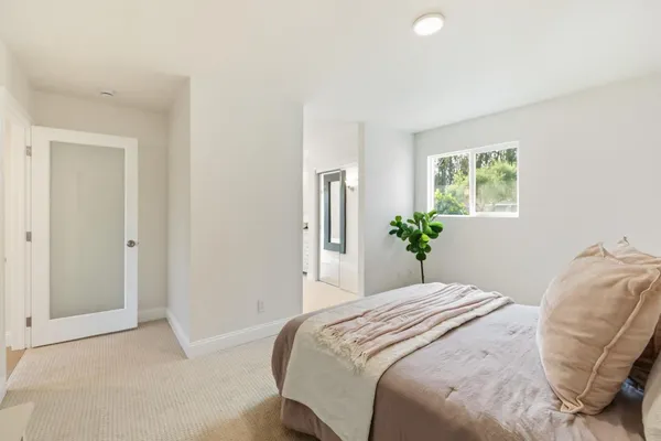 a spacious bedroom with a bed and a night stand