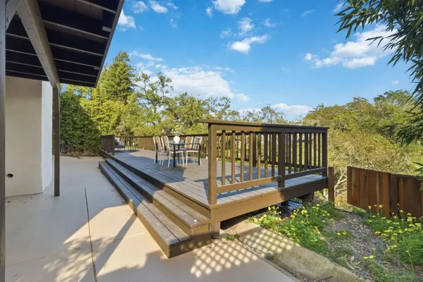a view of a house with wooden deck and furniture