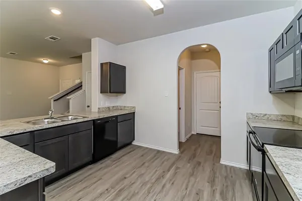 a spacious bathroom with a granite countertop sink a mirror and wooden floor