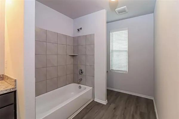 a bathroom with a tub a sink and a window