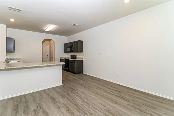 a large white kitchen with wooden floor and a sink