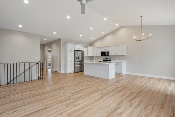 a view of kitchen with granite countertop cabinets and refrigerator