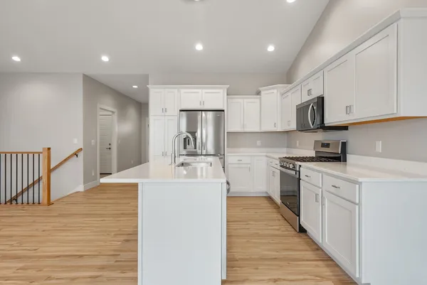 a kitchen with stainless steel appliances granite countertop a sink stove and refrigerator