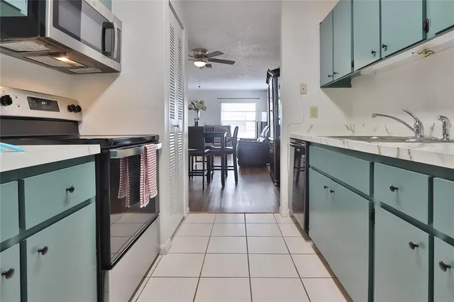 a kitchen with granite countertop a sink a stove and cabinets