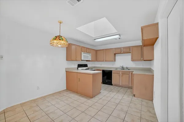 a kitchen with a sink a stove top oven and cabinets