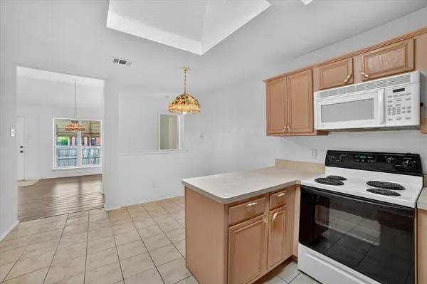 a kitchen with granite countertop a stove a sink and a microwave