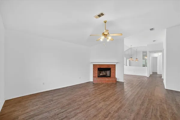 a view of a room with wooden floor and kitchen view