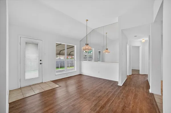 a view of a big room with wooden floor and windows
