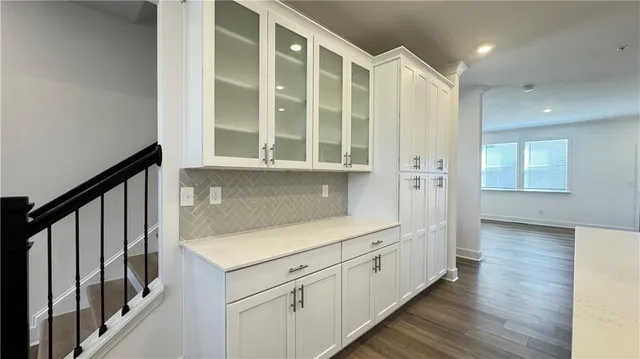 an empty room with wooden floor fireplace and windows