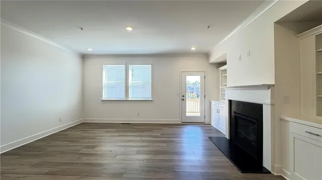 a view of an empty room with a fireplace and a window