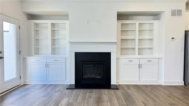 a living room with a fireplace cabinet and a wooden floor