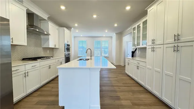 a kitchen with kitchen island a sink a stove and wooden cabinets