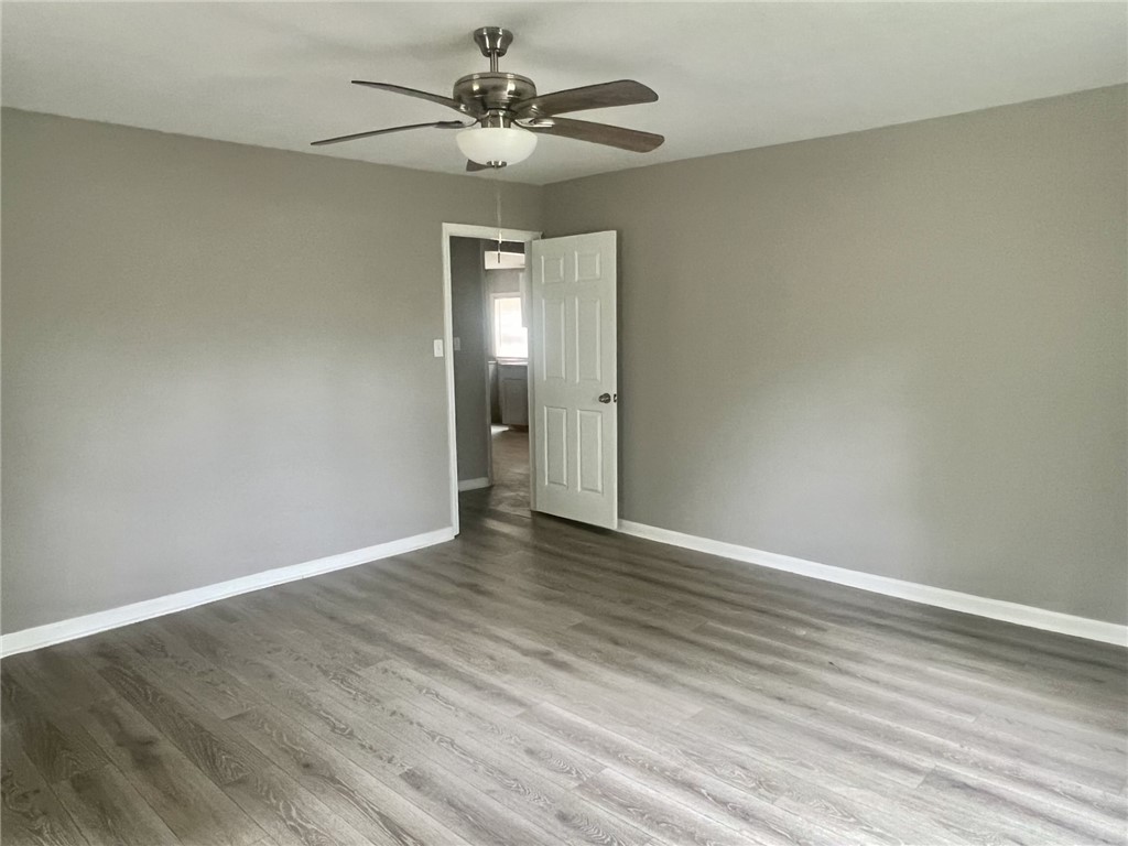 301 Hammett Street Honea Path, SC 29654 - Photo 7 of 14 An inviting room showcasing attractive plank flooring and a contemporary ceiling fan.