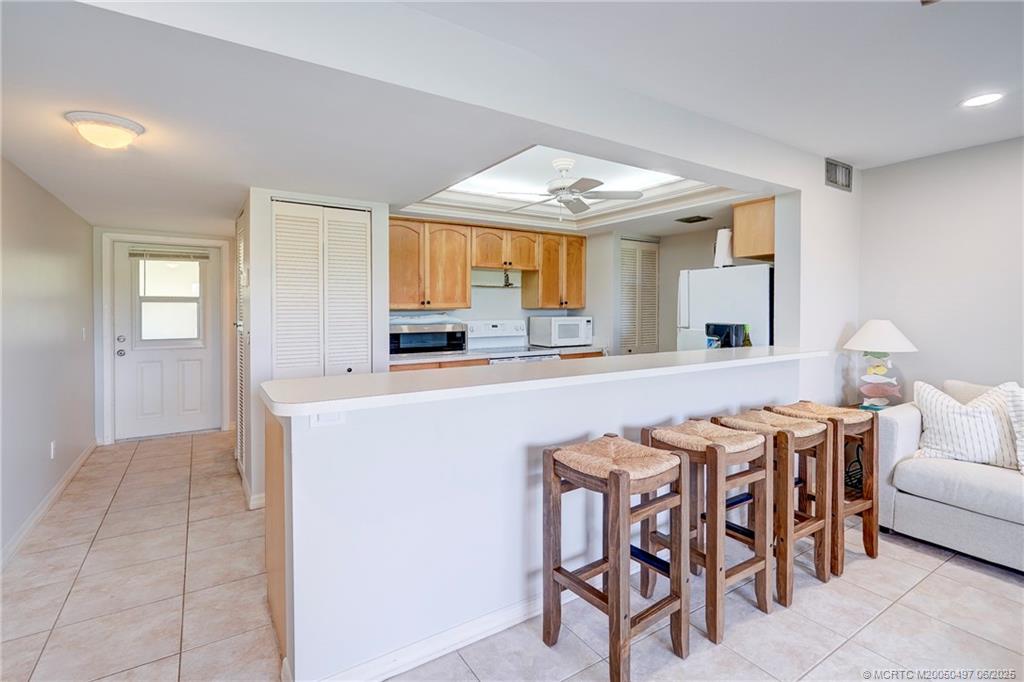 5539 Northeast Gulfstream Way Stuart, FL 34996 - Photo 14 of 26 a kitchen with stainless steel appliances a table and chairs in it