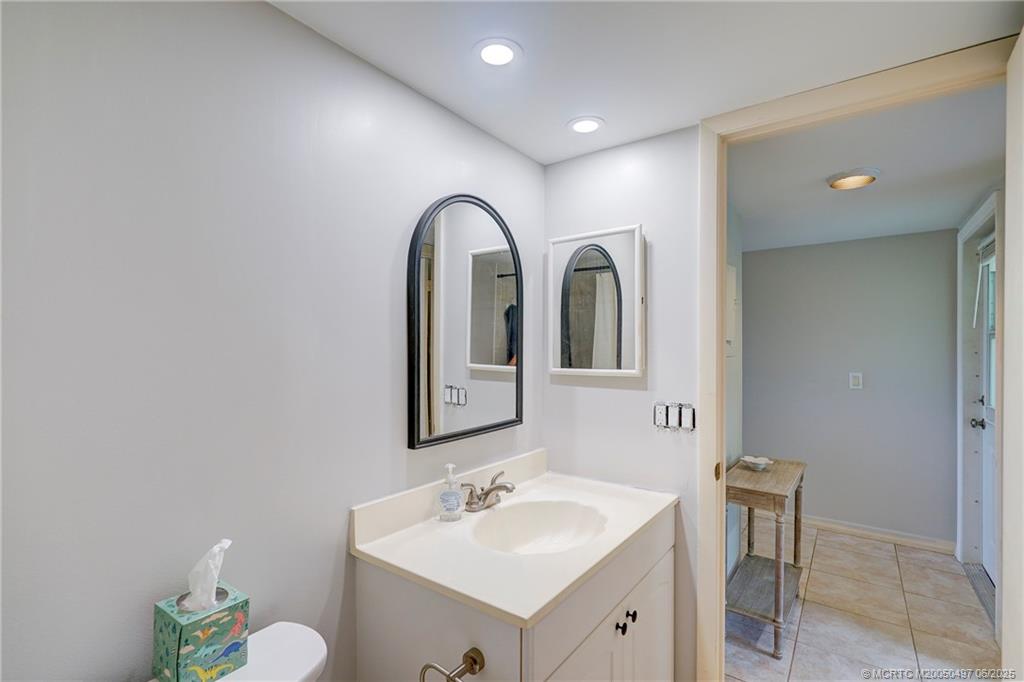 5539 Northeast Gulfstream Way Stuart, FL 34996 - Photo 23 of 26 a bathroom with a sink and a mirror