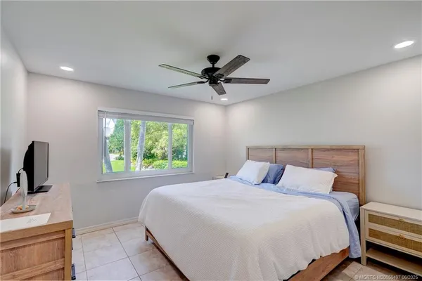 a bedroom with a bed a window and a flat screen tv